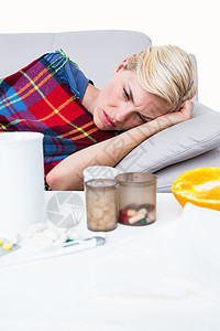 躺在沙发上的金发病女人疾病金发毯子服装女士药品金发女郎感染流感症状背景图片