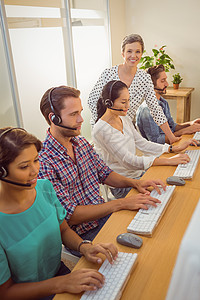 在呼叫中心协助员工的主管人员办公室同事电脑职场沟通女性人士代理人男人工作图片