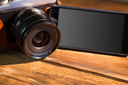 一个漂亮的棕色传统相机 下一个智能手机阴影潮人电话技术照片复兴复古木头摄影背景图片