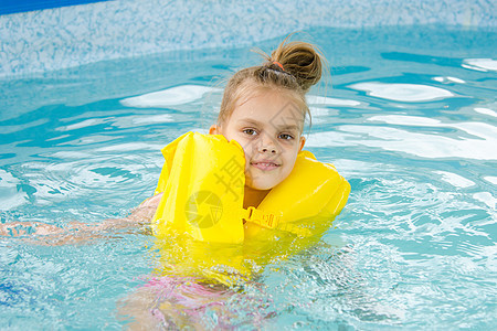 女孩在游泳池游泳 在救生衣的女孩图片