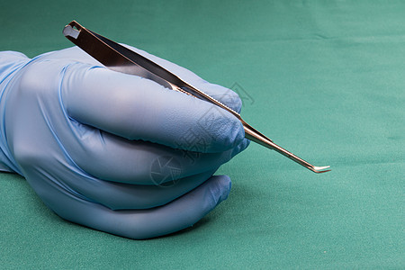 持有微型外科手术工具的外科医生平台保健卫生钳子科学药品夹钳乐器医院手套图片