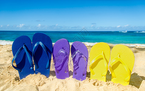沙沙滩上多彩多彩的翻滚海景天空海洋收藏凉鞋乐趣拖鞋蓝色彩虹字拖图片