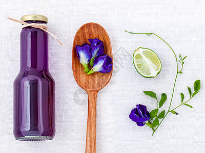 白桌上有健康饮水 在白桌上热带温泉玻璃花瓣藤蔓植物群蝴蝶植物蓝色翅膀图片