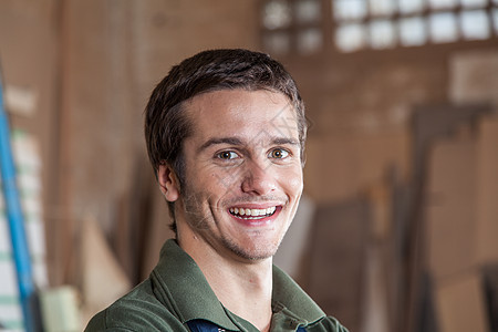微笑者在他的工作间里作坊工人相机工作木匠水平男人木头职业财产图片