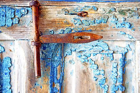 在摩洛科敲门机中涂上肮脏的黑漆 生锈金属隐私蓝色挂锁黄铜指甲钥匙古董木头安全出口图片
