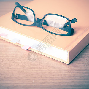 带粘贴纸条和眼镜的书笔记商业学习笔记本日记办公室文档邮政学校贴纸背景图片