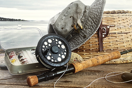 帽子和渔具放在水边的桌上垂钓者齿轮投掷淡水退休娱乐乐趣爱好相片棕色图片