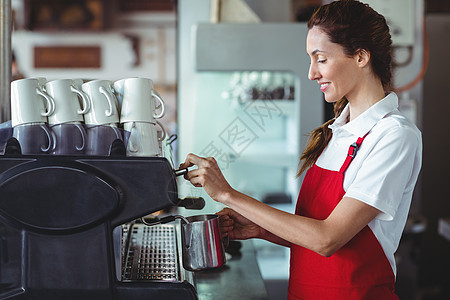 利用咖啡机的漂亮咖啡师金属工作快乐饮料闲暇咖啡屋咖啡零售餐厅商业图片