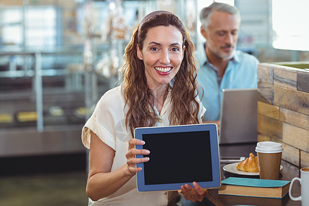 漂亮的黑发 看相机和显示平板电脑男性食物棕色咖啡店铺杯子触摸屏头发女性男人图片