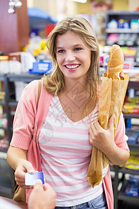 在用信用卡支付现金登记簿上笑容的妇女工人购物市场服装商业面包交易闲暇男人消费者图片