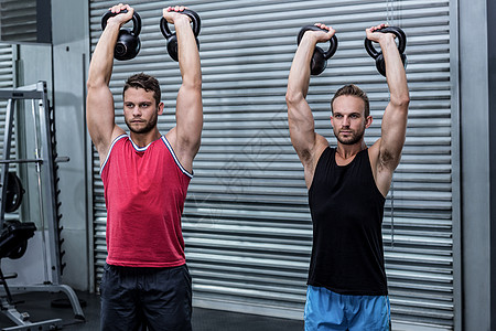 肌肉男人举起一壶水铃健身房中心训练培训师身体肩部调子重量闲暇护理图片