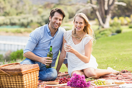 约会的情侣在酒杯里倒红酒活动男性农村野餐篮子公园毯子休闲男人快乐图片