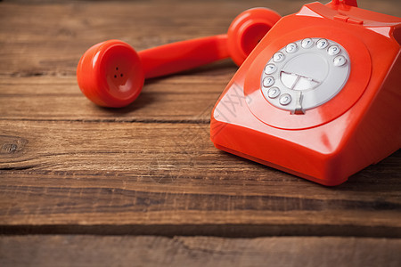 木制桌上的红色电话木头橡木拨号固定电话桌子背景图片