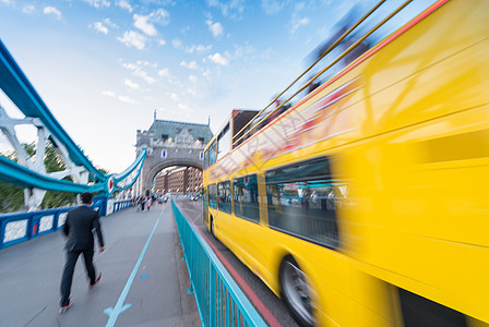 黄色巴士在塔桥上快速行驶的模糊图像图片