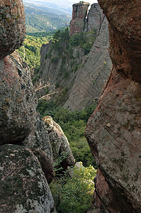 岩石  从一块岩石裂缝中看阳光岩层天空游客群石旅行树木图片