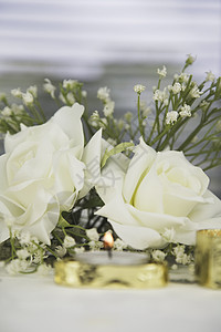 配有假玫瑰和金色蜡烛的婚纱装饰背景图片