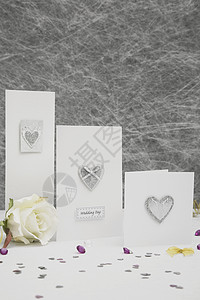 在白桌布上加金肋骨的结婚贺卡装饰品丝带纸屑结婚日白色金子婚礼黄玫瑰背景餐桌图片