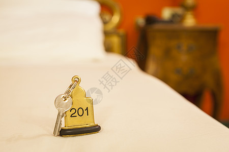 酒店房间钥匙 用钥匙环躺在床边安全金属戒指金子小路空白黄铜剪裁说谎阴影图片
