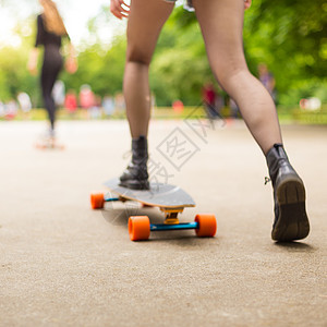 青少年女孩在城市骑长板车长板娱乐运动文化运动鞋闲暇乐趣女士爱好喜悦图片