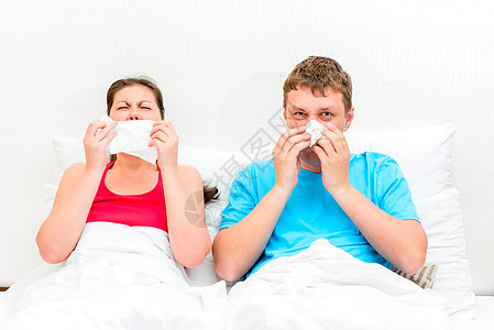 已婚的年轻夫妇在床上生病并打鼻涕图片