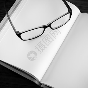在笔记本黑白颜色调色风格上的 眼镜桌子教育时间文档文书作品活页记事本日记规划师图片
