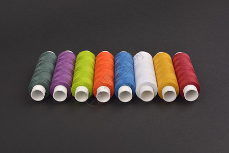 暗背景上的彩色串线工作裁缝团体针线活缝纫维修爱好纤维纺织品材料图片