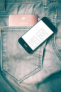 吉安护照口袋里有智能电话古老风格裤子旅行身份机动性蓝色屏幕互联网牛仔裤棉布手机图片