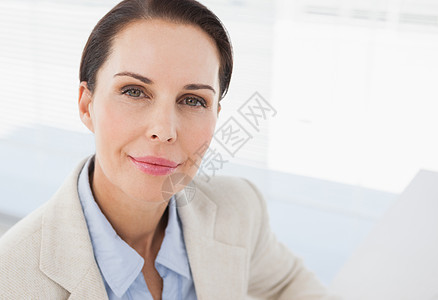 紧贴着微笑的女商务人士快乐人士套装女士办公室桌子女性公司商务头发图片