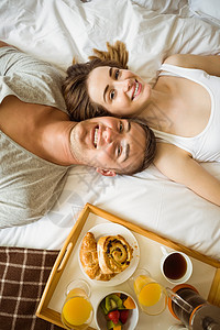 情侣在床上吃早餐男性微笑卧室面包公寓睡衣橙汁男人感情家庭图片