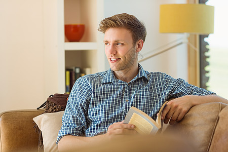 年轻人在沙发上读书家庭衬衫长椅公寓阅读快乐闲暇男人服装家庭生活图片