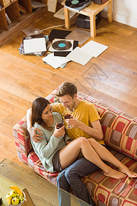 年轻夫妇在沙发上享受红酒休闲客厅公寓酒瓶长椅家庭生活男性闲暇夫妻拥抱图片