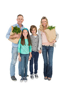微笑的家庭站着拿着一袋健康食品包母亲儿子纸袋女性女孩男人父母男生成人孩子图片