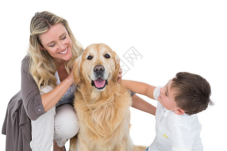 微笑的母亲和儿子抚摸着他们的金色猎物家庭服装家长成人宠物女性休闲童年男生感情图片
