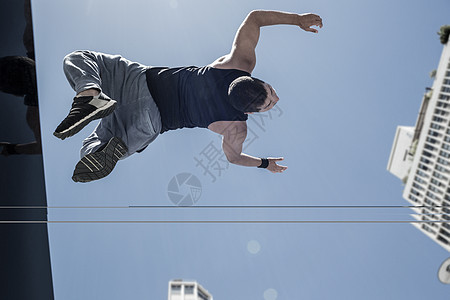 健体男在城里做后回翻转运动城市生活青年体操休闲都市蓝天挑战训练活力图片