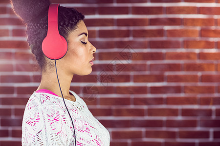 一个美丽的女人 专注在她的音乐上牛仔布红色混血白色女士听力倾斜长发黑发耳机背景图片