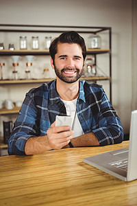 年轻学生享受咖啡并使用智能手机的年青学生男人活动餐厅咖啡馆行业顾客笔记本手势电脑食品图片