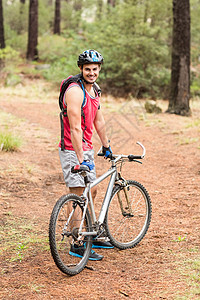 骑自行车看摄影机的帅帅帅摩托车手自由森林环境手套男人微笑活动娱乐闲暇头盔图片