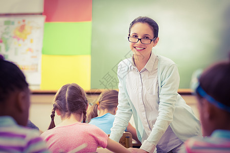 教师在课堂上帮助学生瞳孔教育学校快乐童年孩子小学女性眼镜老师图片