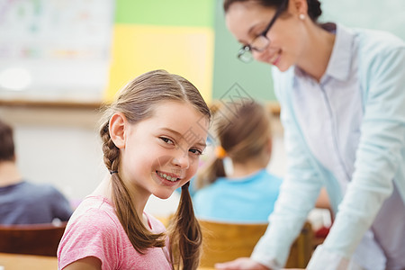 教师在课堂上帮助学生职业孩子眼镜小学生老师知识桌子教育班级同学们图片