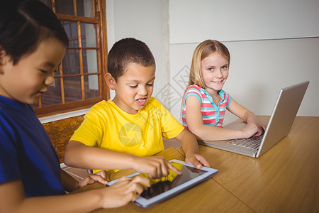 使用笔记本电脑和平板电脑在班中选美学生混血小学课堂班级教育小学生女孩男性技术男生图片