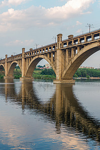 沿河的铁路和铁路两极分桥地标天空旅行快手运输建筑蓝色城市背景图片