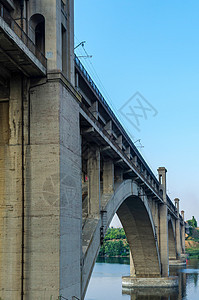 沿河的铁路和铁路两极分桥蓝色运输地标快手城市旅行建筑天空背景图片