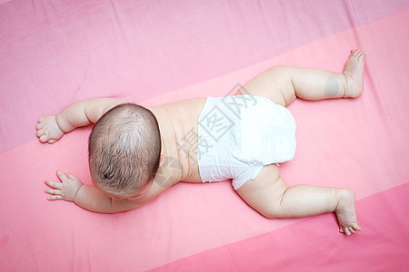 亚洲女婴翻过粉红色的床图片