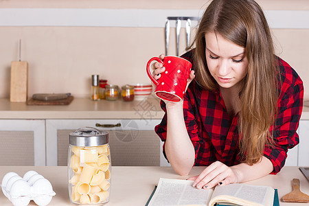 穿红衬衫的女孩喝茶看书 厨房 横向图片