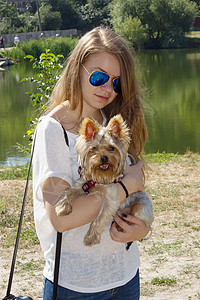 快乐的年轻女孩拥有与日方田鼠狗假期照片动物女士朋友友谊犬类乐趣公园毛皮图片