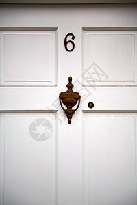 门上的钉子和灯光 在隆登古型棕褐色门的手柄上图片