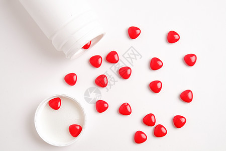 白桌上的红色药丸白色药店治疗疾病药品药片医疗制药药物瓶子图片