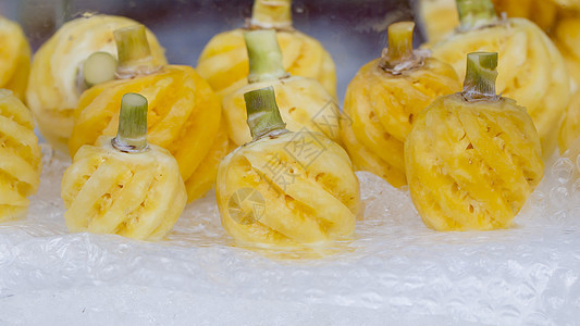 市场冰面上剥皮的小菠萝水果黄色绿色饮食果汁热带营养食物图片