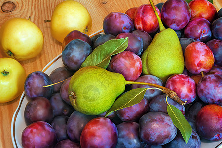木制桌上的陶瓷盘里的水果产品季节健康饮食饮食美食食物宏观团体李子花园图片