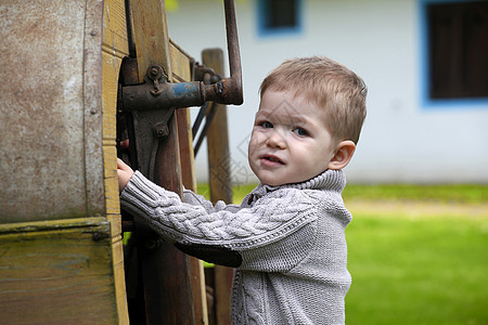 2岁有2岁好奇心的婴儿男孩 用老农马术管理农业金属羊毛农场乡村小男孩木头机器孩子们村庄图片